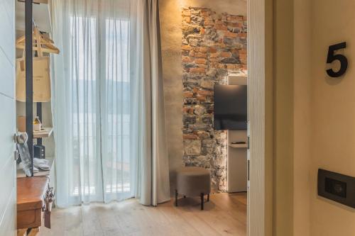 a living room with a stone wall and a chair at La Corte del Lario - La Cortesella in Varenna