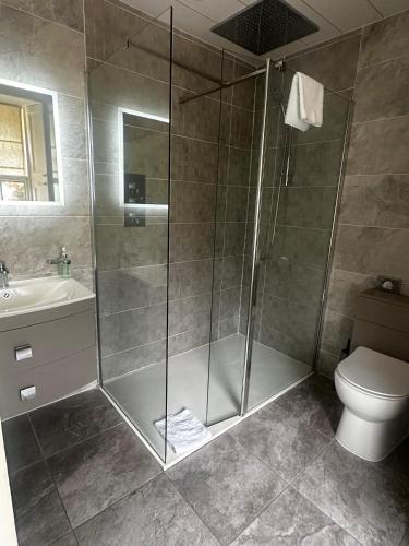 a bathroom with a shower and a toilet and a sink at Loch Ness Country House Hotel in Inverness