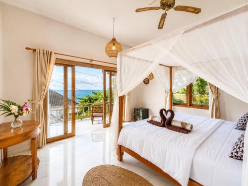 a bedroom with a white bed with a view at SūKha Amed in Culik