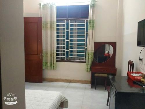 a room with a mirror and a desk and a window at Hottel ANH LONG in Buôn Ðũng