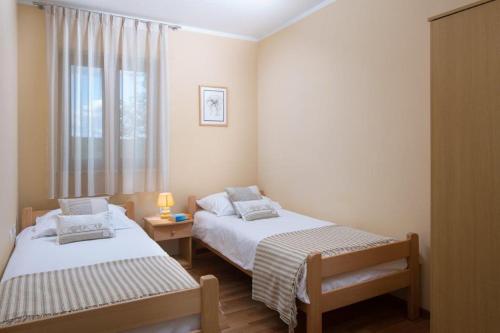two beds in a small room with a window at Vila Charlie in Labin
