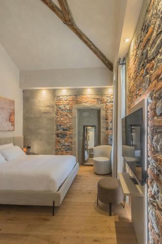 a bedroom with a bed and a stone wall at La Corte Del Lario - San Giorgio in Varenna
