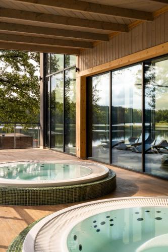an indoor swimming pool in a house with windows at Aries Lago Park Hotel & SPA, Mazury in Olsztynek