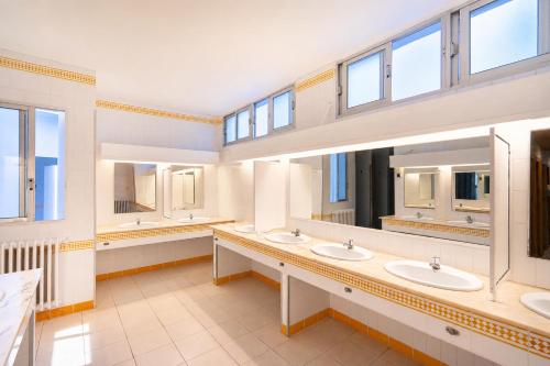 a bathroom with three sinks and two mirrors at Kampaoh Benicàssim in Benicàssim