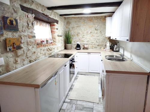 a kitchen with white cabinets and a sink at Slavotova hiža in Mračin