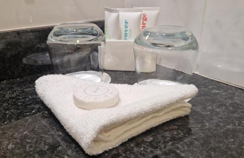 a bathroom counter with a towel and glass containers at Mullingar Park Hotel in Mullingar