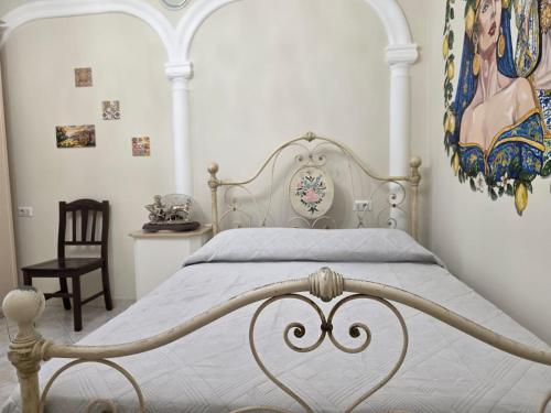 a bedroom with a white bed and a painting on the wall at Sicilia Mount&Sea in Mascali
