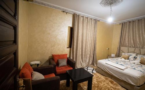 a bedroom with a bed and a couch and a chair at Villas khadija in Marrakesh