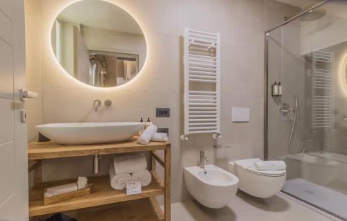 a bathroom with a sink and a toilet and a mirror at La Corte del Lario - Contrada dei Sarti in Varenna