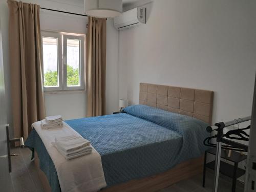 a bedroom with a blue bed and a window at Refúgio Viçoso in Vila Viçosa