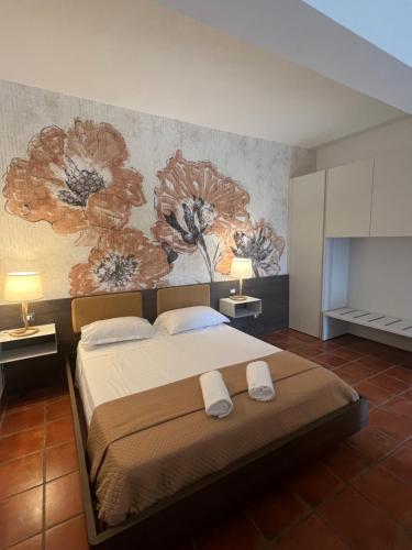 a bedroom with a large bed with flowers on the wall at Agriturismo Tenuta de Castro in Aprilia