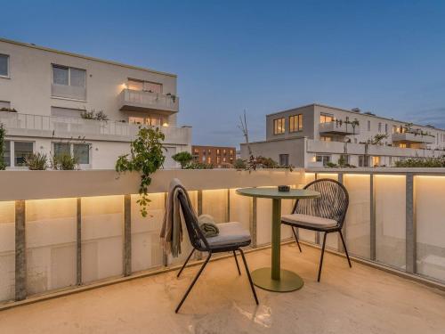 a patio with two chairs and a table on a balcony at Limehome Dresden Wallstraße - Digital Access in Dresden
