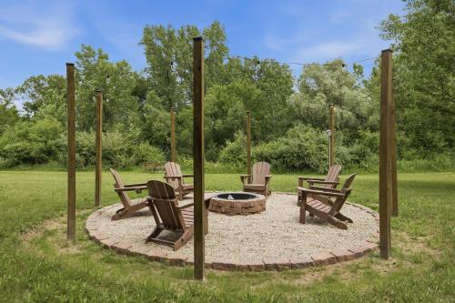 three chairs around a fire pit in a yard at County Line Cabin in Woodland Beach