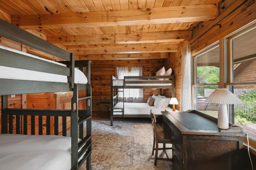 a bedroom with bunk beds and a desk and a bed at County Line Cabin in Woodland Beach