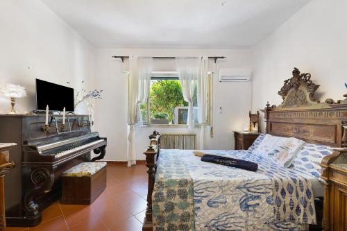 a bedroom with a bed next to a piano at Pietra nel mare in Pietra Ligure