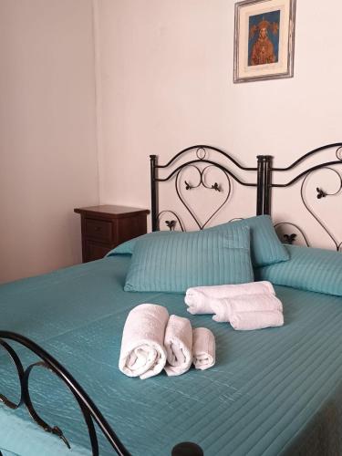 a bed with two towels and two rolled towels at Il Castello in Viggiano