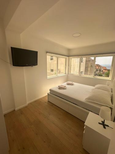 a bedroom with a bed and a flat screen tv at Apartmani Paula in Makarska