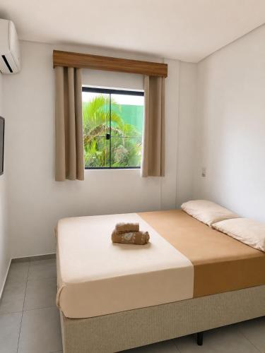 two beds in a room with a window at Pousada São José in Joinville