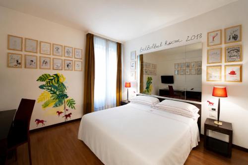 a bedroom with a large white bed and a mirror at Phi Hotel Bologna in Bologna