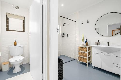 a white bathroom with a toilet and a sink at 8 on Nivenia in Bettyʼs Bay