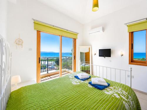 a bedroom with a bed with a view of the ocean at Argaka Sunset Villa in Argaka