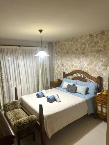 a bedroom with a large bed and a chair at Es Cantonet in Calvià