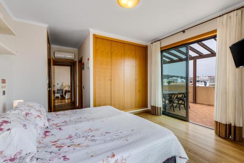 a bedroom with a large bed and a balcony at Algarve 360º Experience in Loulé