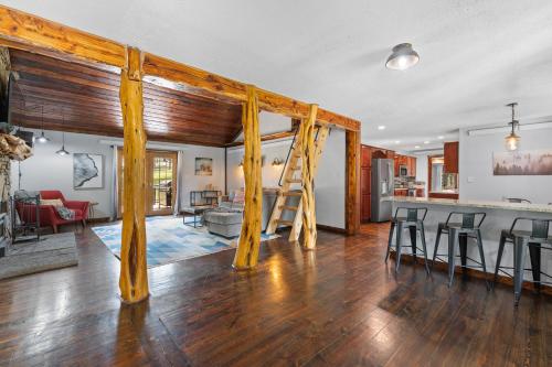 a living room and kitchen with wooden beams in a house at Tatanka Hideaway Hot Tub Pool Table Massive Space in Custer