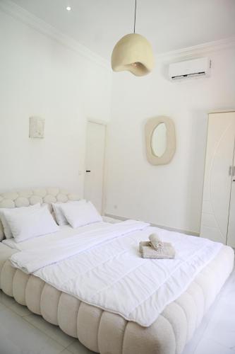 a white bedroom with a large white bed with towels on it at Villa Marrakech ,Piscine Privée & Luxe Authentique in El Aggada