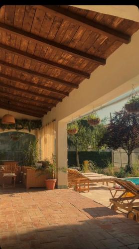 a patio with a wooden pergola and tables and chairs at Casa Olive Costinești in Costinesti