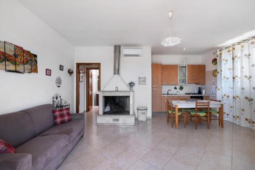 a living room with a couch and a table and a fireplace at Le Crapare in Muro Leccese