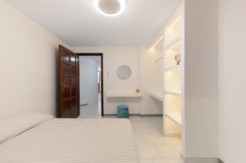 a white bedroom with a bed and a closet at cmv Salento in Marina di Pescoluse