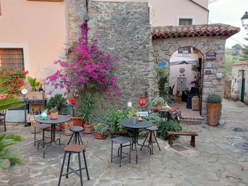 an outdoor patio with tables and chairs and flowers at Casa Marina, casa Vacanza, Suite Indipendente Cilento in Ceraso