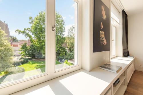 an empty room with large windows with a view at B&B Huyze Weyne in Bruges