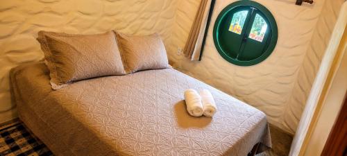 a small bed in a small room with a mirror at Cabana Refúgio do Hobbit-Gramado @refugiodohobbit in Gramado