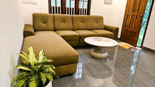 a living room with a couch and a table at Villa Terra, Spacious 2BR Villa in Kannur