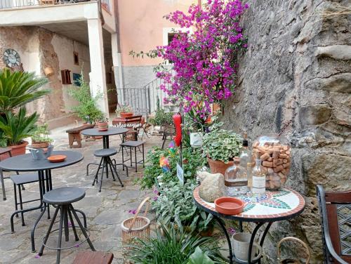a patio with tables and chairs and purple flowers at Casa Marina, casa Vacanza, Suite Indipendente Cilento in Ceraso