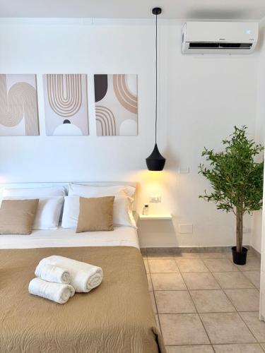a bedroom with a bed with two pillows on it at S'Olivare Posada - Apartments in Posada