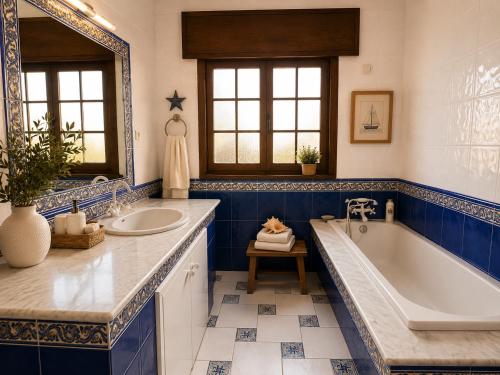 a blue and white bathroom with a tub and sink at Holibai Vila Santa Rita Vistas al mar cerca de Baiona in Oia