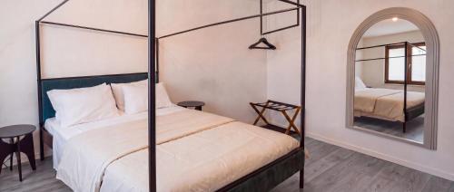 a bedroom with a four poster bed and a mirror at OverGarden Rooms in Dossobuono