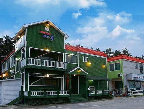 a green building with a sign on top of it at Buan Floor Pension in Buan