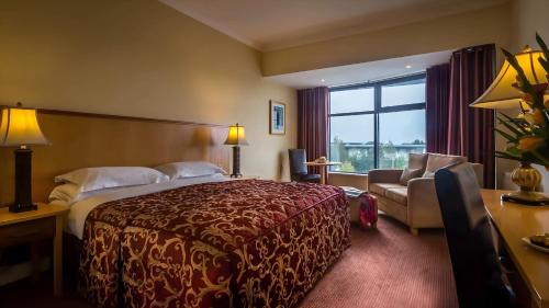 a hotel room with a bed and a couch and a window at Mullingar Park Hotel in Mullingar