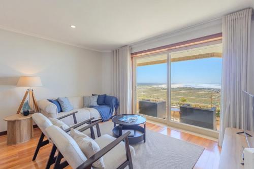 a living room with a couch and a large window at Ocean View Luxury Duplex Apartment in Ovar