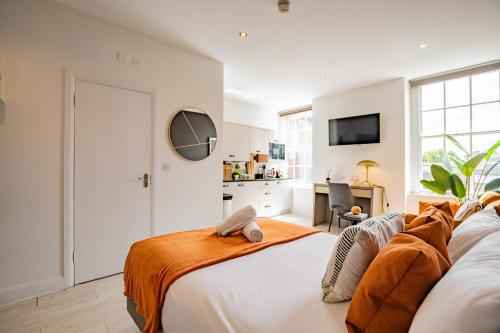 a bedroom with a bed with an orange blanket on it at Dublin Central Suites in Dublin
