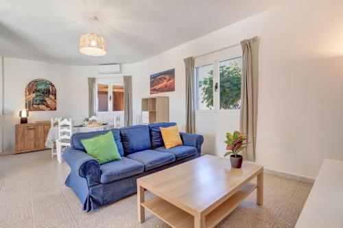 a living room with a blue couch and a table at Villa Brisa de Gairia in Antigua