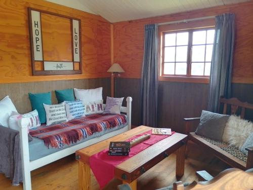 a bedroom with a bed and a table and a mirror at Faith Cabin in Waterval-Onder