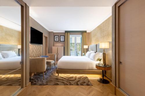 a bedroom with two beds and a desk with a television at Tivoli Palazzo 1880 Lecce Hotel in Lecce