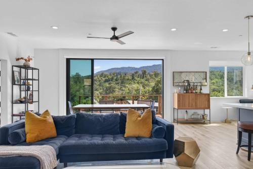 a living room with a blue couch and a large window at Chardonnay Getaway in Glen Ellen