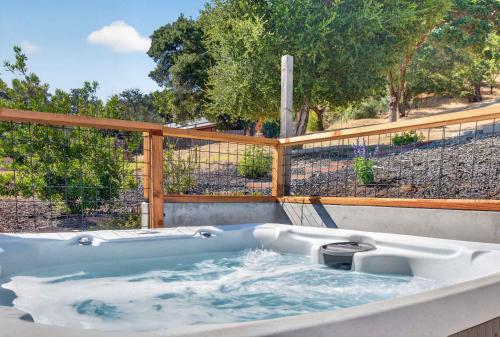 a hot tub in a backyard with a fence at Chardonnay Getaway in Glen Ellen