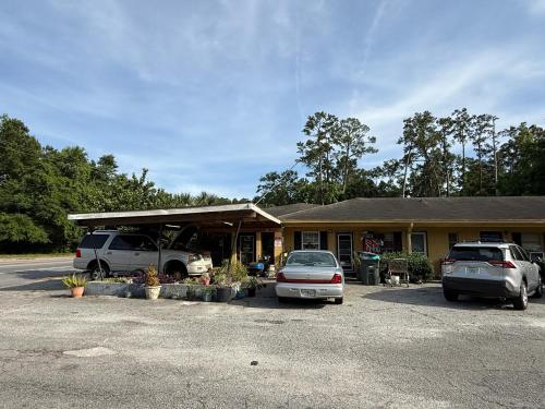 two cars parked in a parking lot in front of a building at Kings Suites Near Naval Base I-95 Kingsland in Kingsland